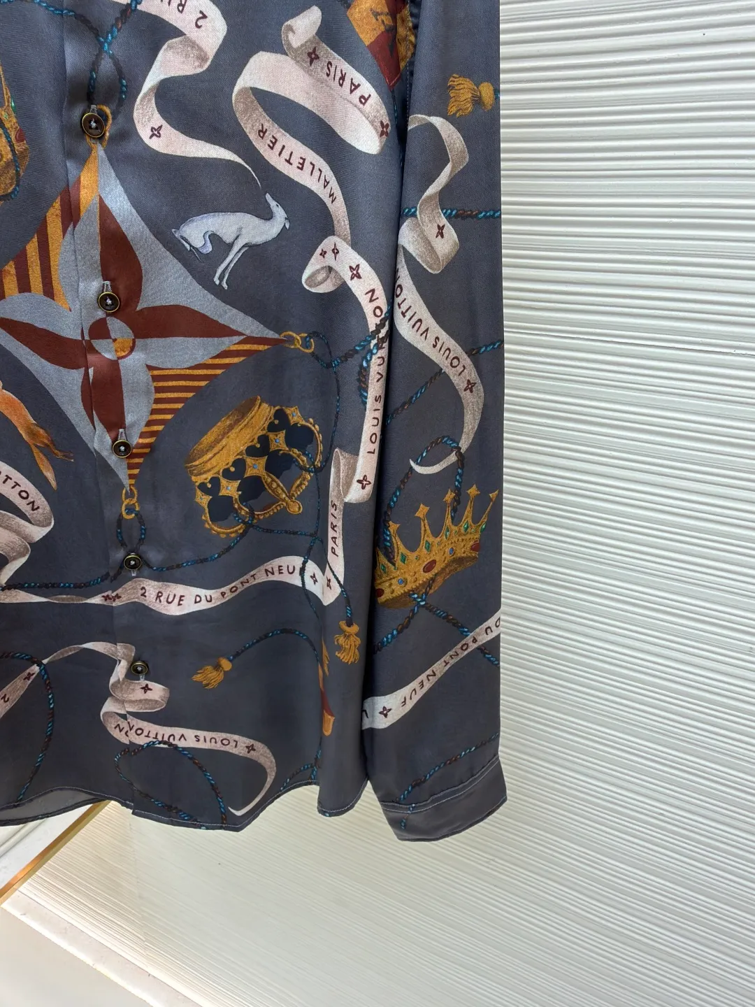 LOUIS VUITTON lapel printed mulberry silk shirt ●Original version: Purchased and developed for 17000 ●Item number: 1682218-A85 ●Fabric: worsted mercerized imitation Tencel fabric ●Technology: made by positioning cutting machine ●Color: gray ●Version: fitted version ●Weight: about 190 grams ●Size: S-M-L-XL ●Description: This printed long-sleeved shirt is made of 19mm mulberry silk and cotton blended fabric, which is made through high-density weaving process. The fabric combines the smooth luster of silk with the crisp and breathable characteristics of cotton, and has excellent wrinkle resistance and drape. The body printing adopts digital direct inkjet printing combined with manual overlay screen printing process. First, digital direct inkjet is used to restore the delicate texture and gradient color of the crown, ribbon and other patterns, and then manual overlay screen printing is used to superimpose metallic texture ink to make the three-dimensional relief and glossiness of the pattern more prominent. After high-temperature fixation and water washing tests, the color fastness reaches level 4 or above. The collar of the shirt adopts an inlaid collar design, which is combined with high-temperature pressing and shaping technology to make the collar stiff and not easily deformed; the placket is made of hand-locked hemming technology, and the buttons are made of natural horn buttons, each of which is polished by hand; the side seams are made of French double-needle chain stitching, and the cuffs are designed with adjustable cuffs, showing fine workmanship in every detail. The overall wiring is straight and delicate, the fabric is comfortable and soft, and the color is consistent without color difference. It can be matched with the same style to create a fashionable look and control various occasions. Customized accessories, complete with three standards, same style for men and women!